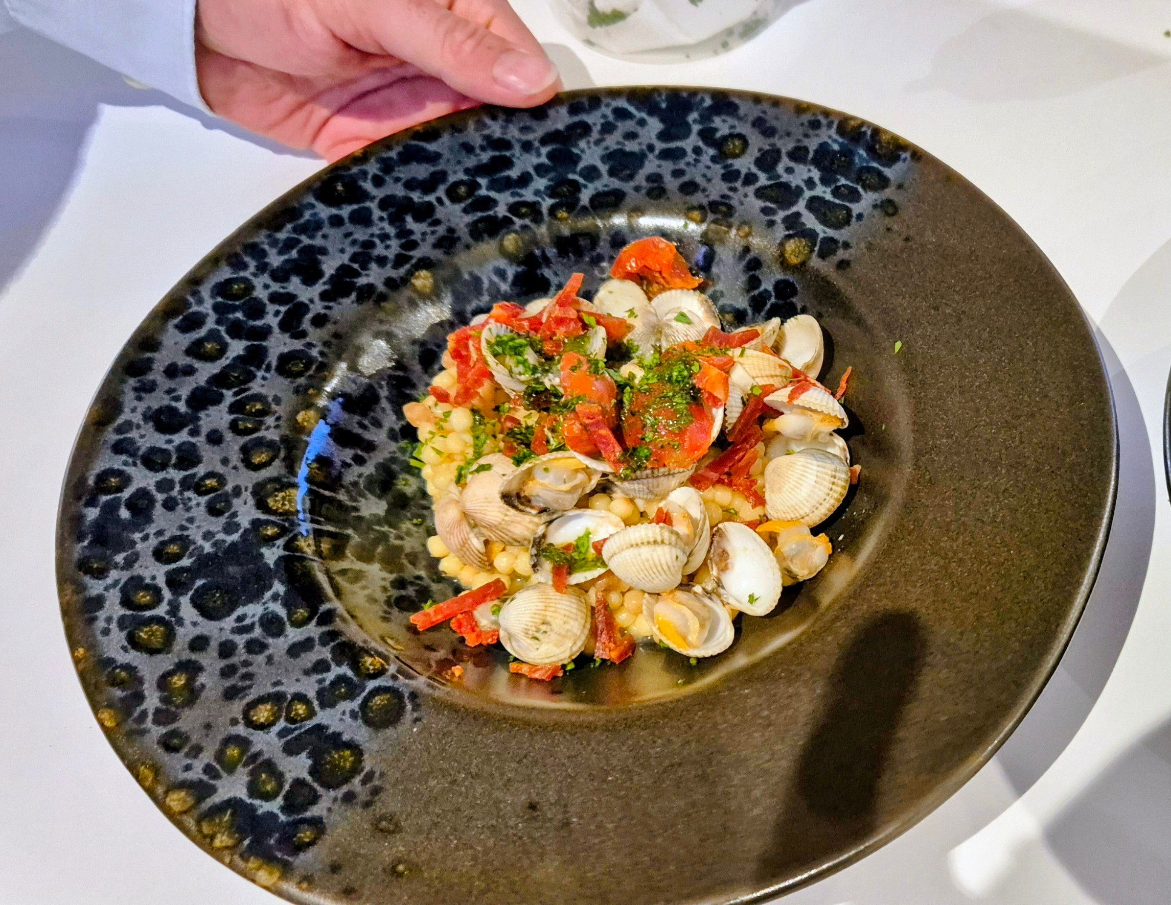 Assiette de fruits de mer et palourdes présentée par le chef